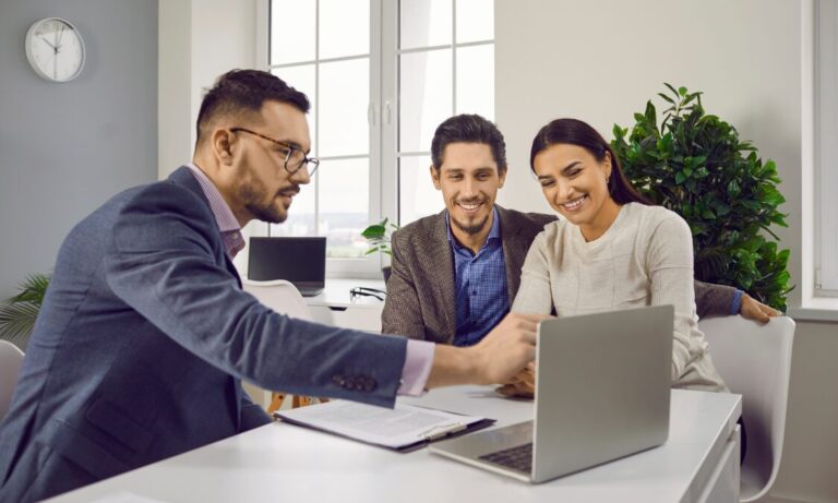 Letting agent discussing property details with clients using a laptop, representing Leeds landlord advice, faster lets and rental property management.
