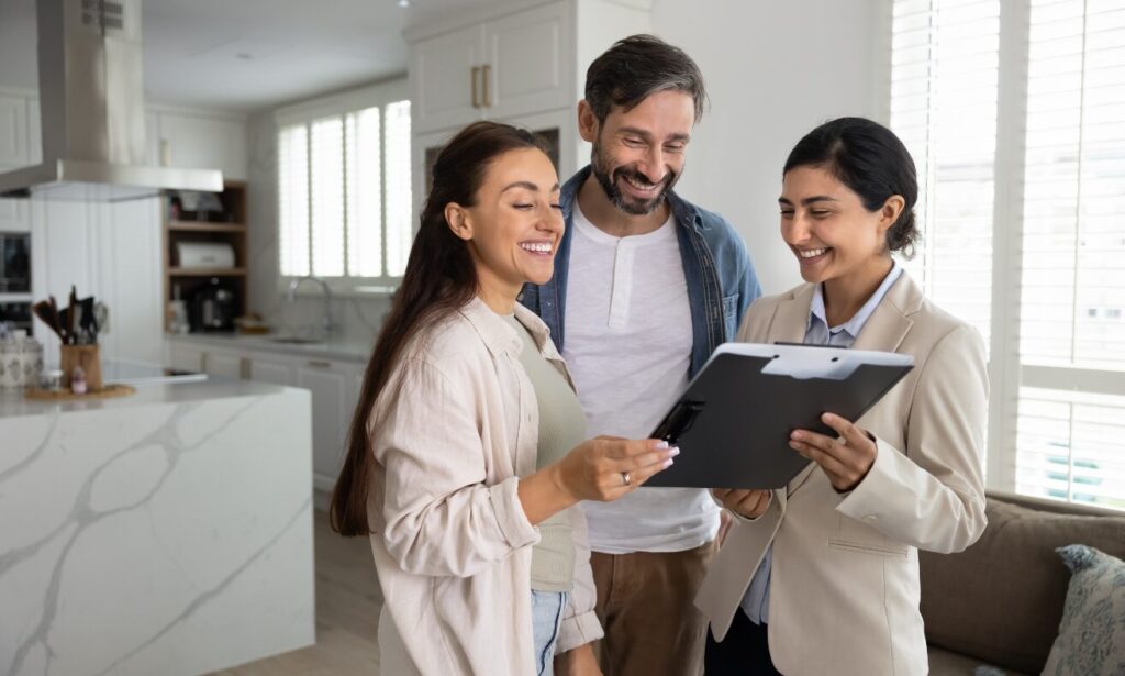 Estate agent showing property details to clients inside a modern home, representing living in Earlswood B94, local property advice and buyer or renter guidance.