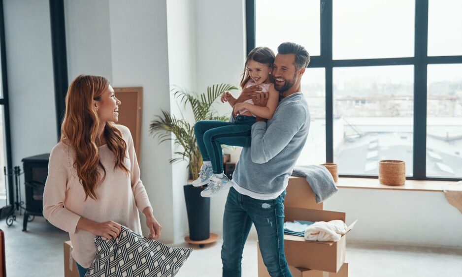 Family unpacking in a bright new home, illustrating buyer demand and school catchment influence on Dumfries house prices in 2026.