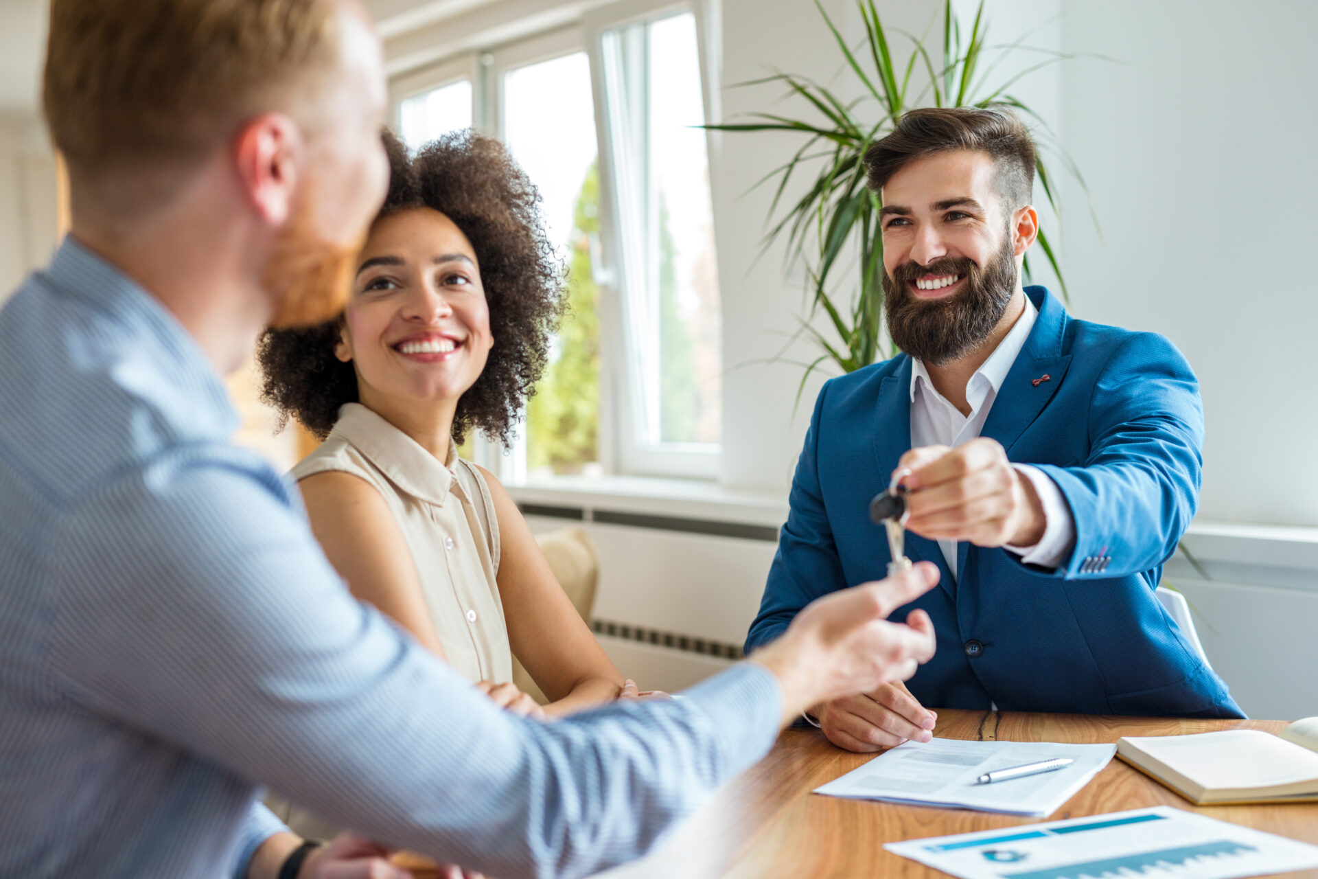 Property manager handing keys to landlords while discussing tenancy documents, representing professional property management in Bishopsworth.