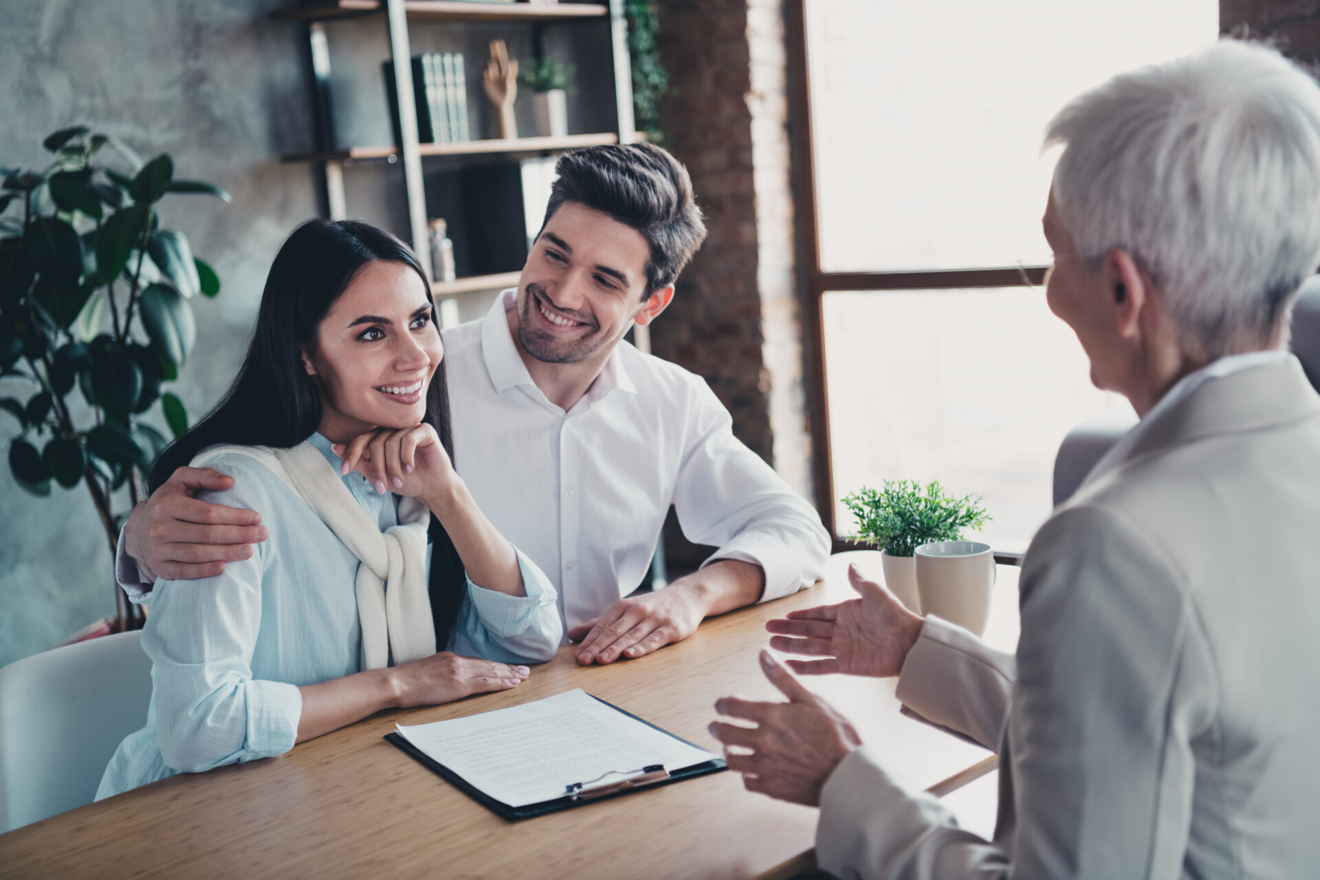 Property professional discussing rental documents with a couple, representing landlord advice and buy-to-let opportunities in Leeds.