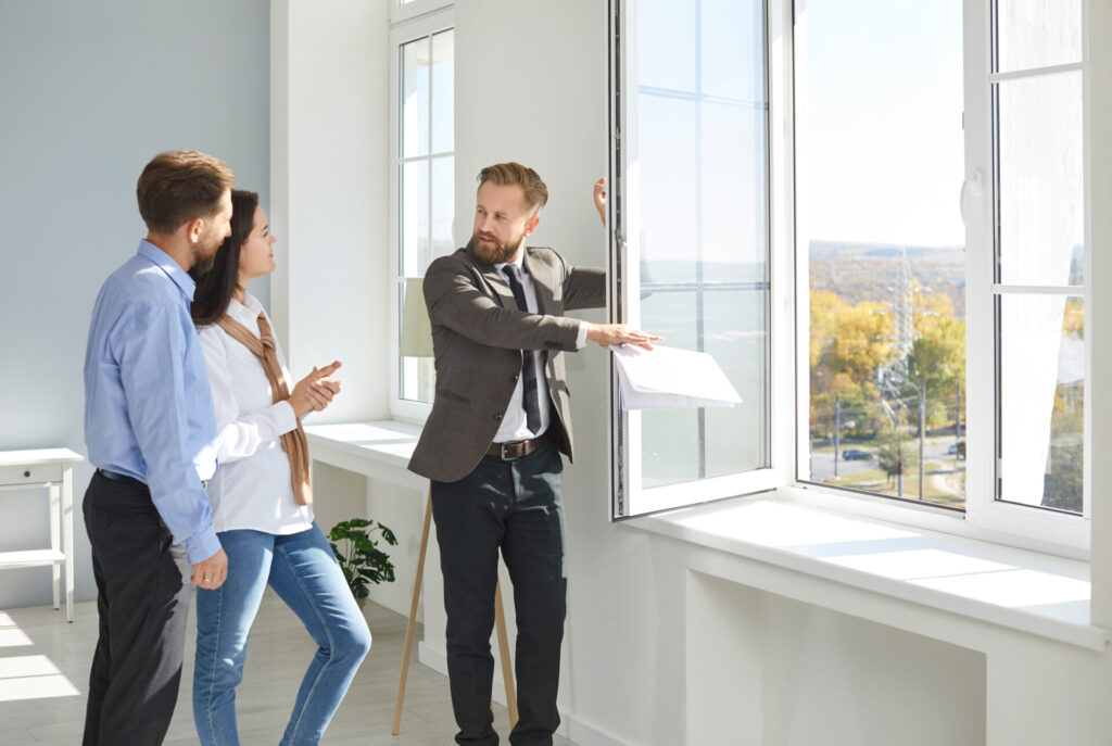 Letting agent showing a bright rental property to a couple, representing landlord investment and rental opportunities in Chesterfield.
