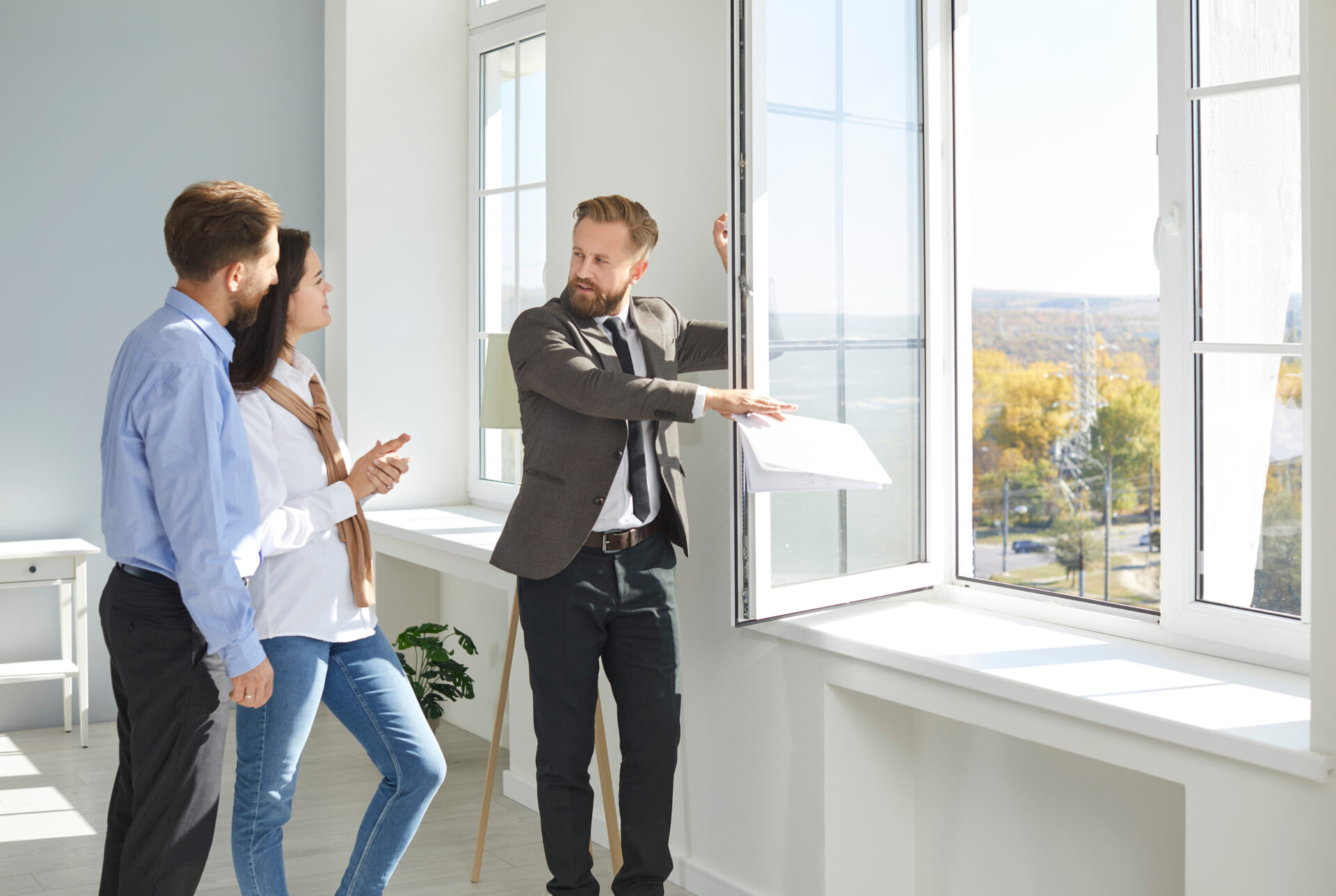 Letting agent showing a bright rental property to a couple, representing landlord investment and rental opportunities in Chesterfield.