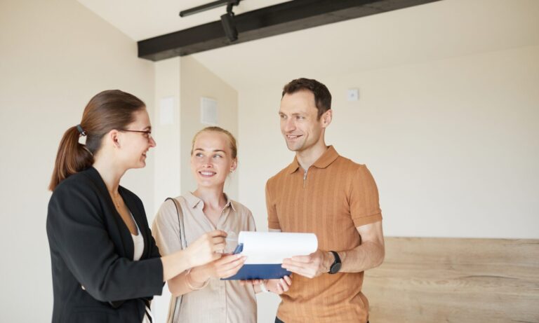 Letting agent reviewing property documents with a couple inside a rental home, representing landlord advice and lettings support in Gravesend.