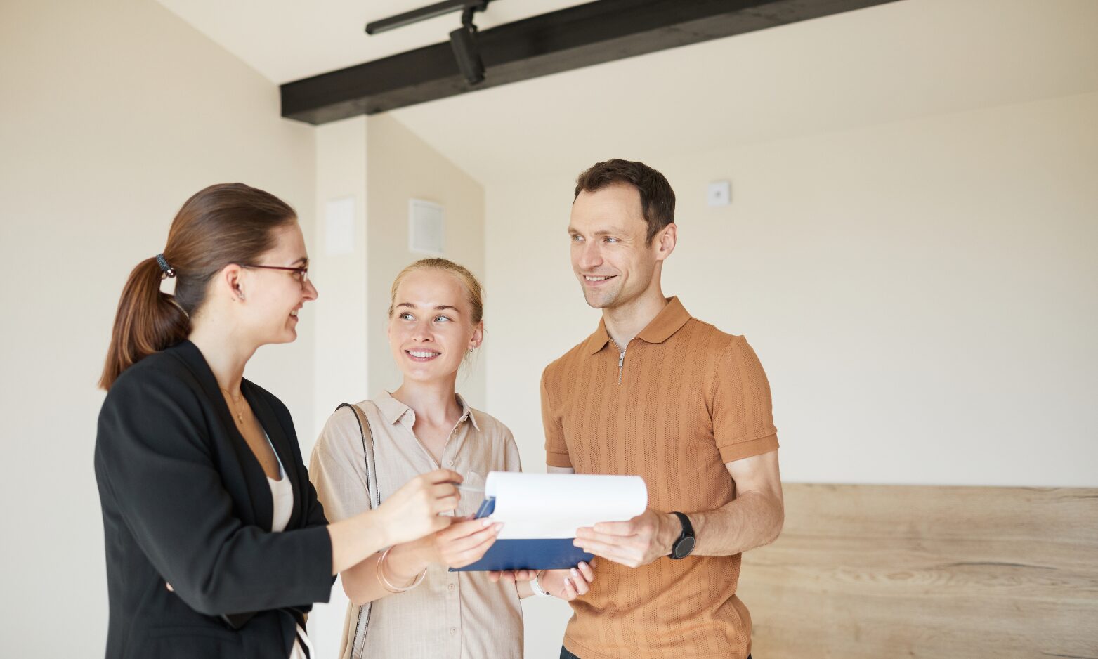 Letting agent reviewing property documents with a couple inside a rental home, representing landlord advice and lettings support in Gravesend.
