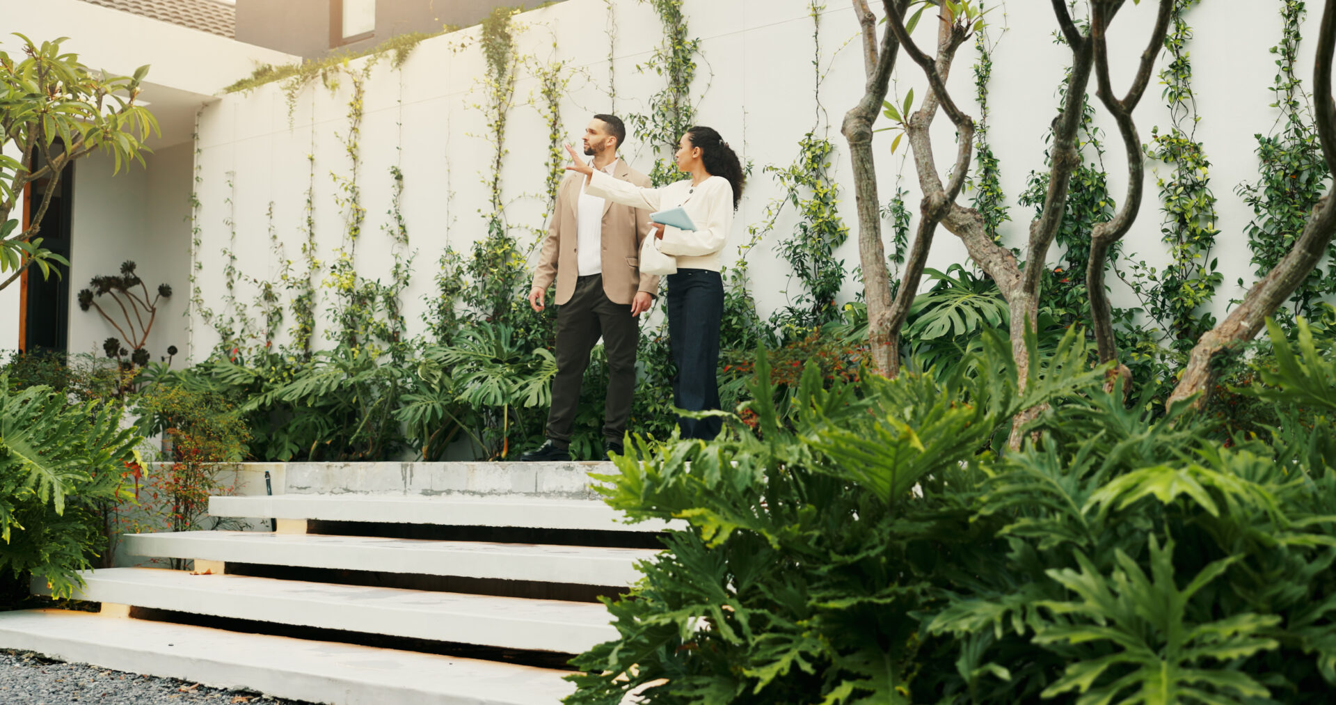 Property professional showing clients around a modern home with landscaped outdoor space, representing the Harborne rental market.