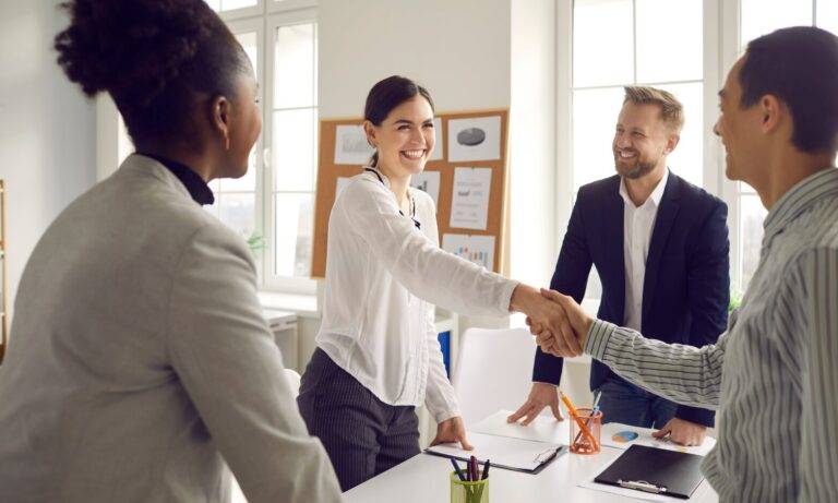 A letting agent shaking hands with landlords during a property management consultation in Tamworth.
