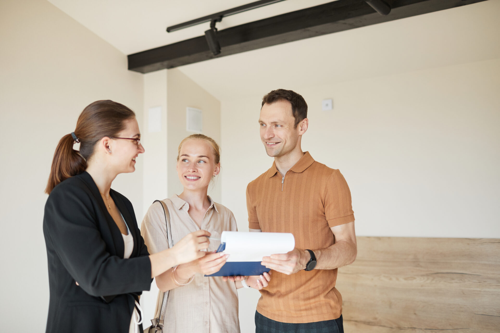 Estate agent speaking with a couple inside a home, representing sellers discussing their Kendal property valuation.