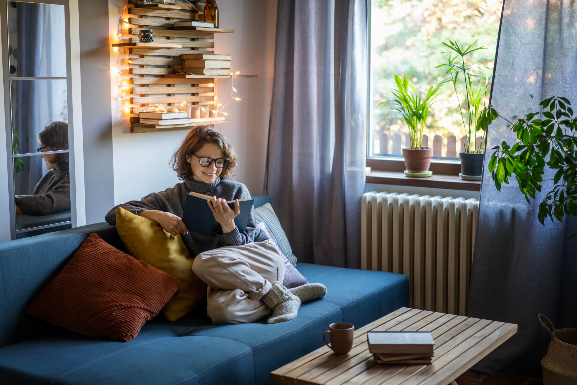 Woman relaxing at home while reading, representing buyers and sellers reviewing Solihull and Birmingham property prices in 2026.