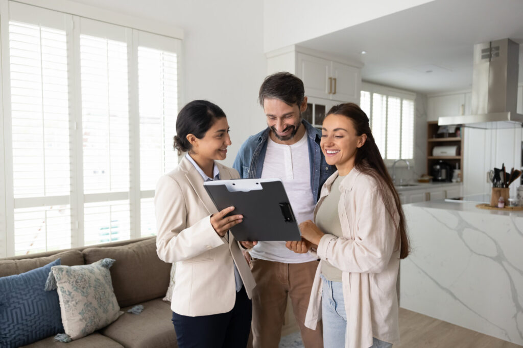 Estate agent showing property details to a couple inside a modern home, reflecting selling advice and local market guidance for Sutton Coldfield homeowners.