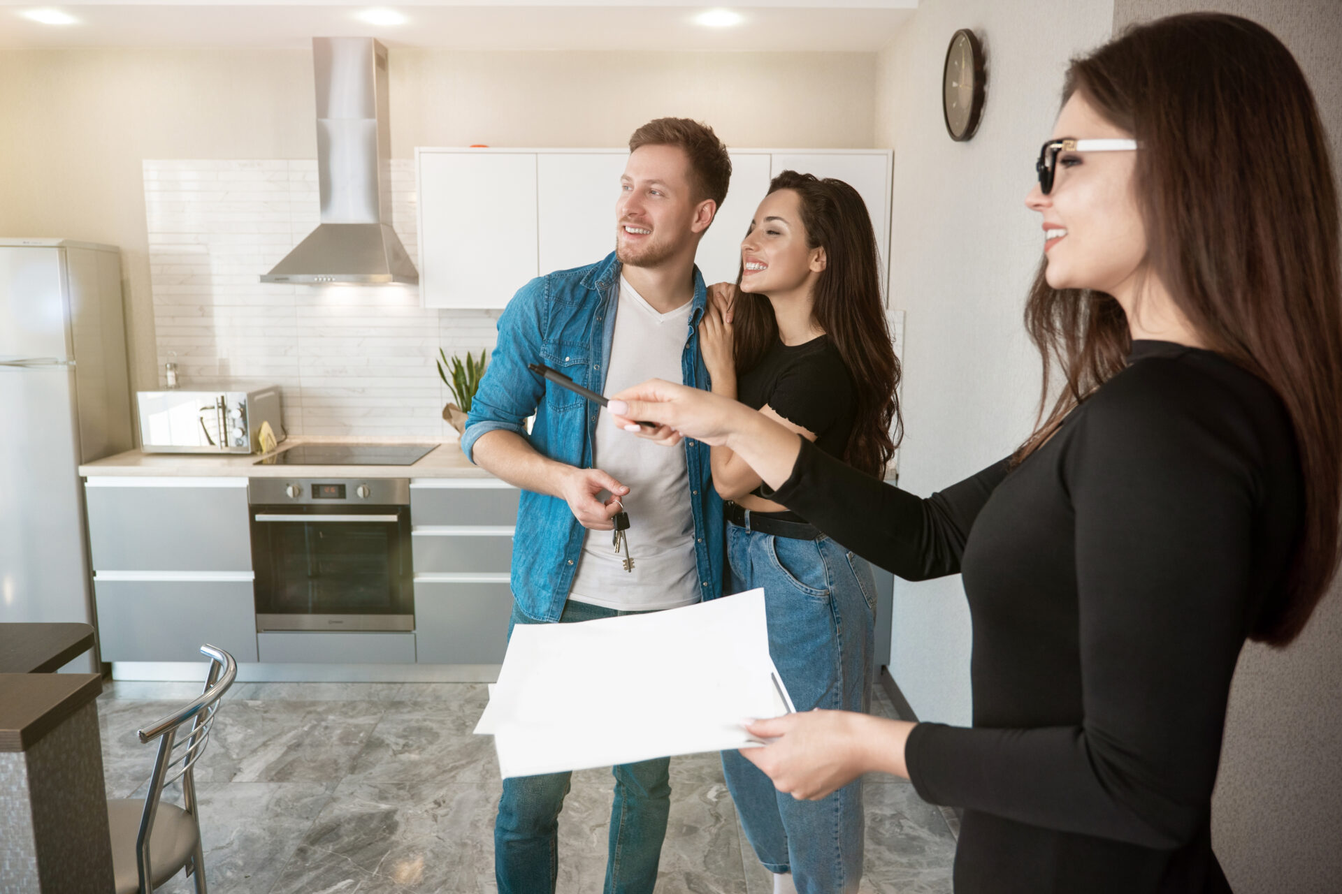 Estate agent showing a couple around a modern kitchen, reflecting property valuation advice and the process of selling a home in Consett.