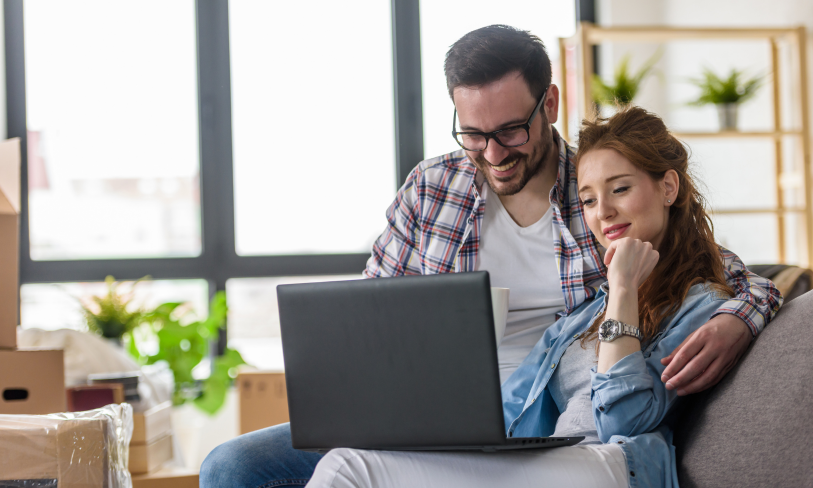 Couple researching Gravesend property prices and home valuations online.