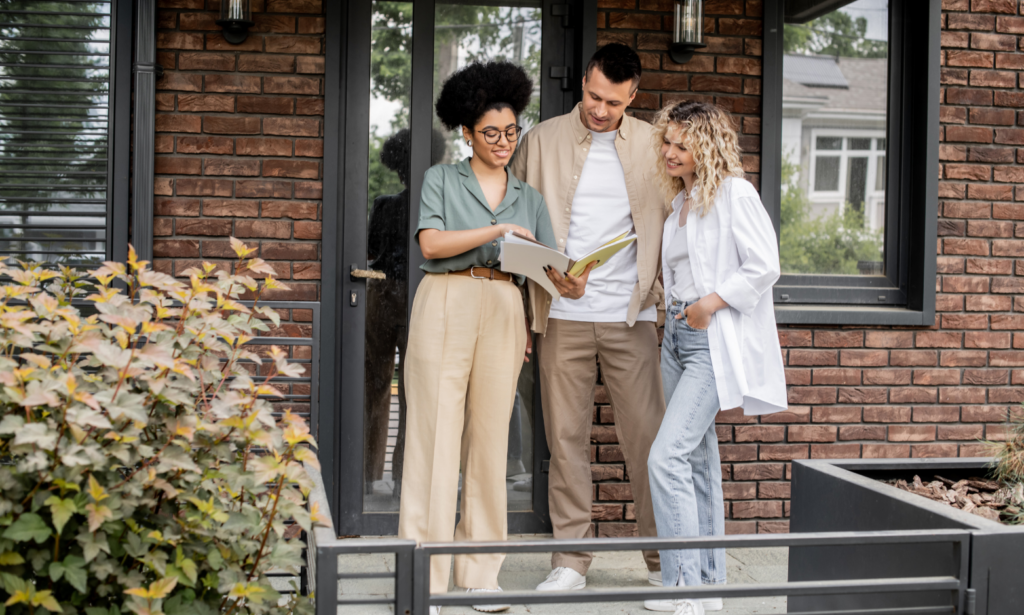 Estate agent discussing property documents with landlords outside a rental home in Leeds.