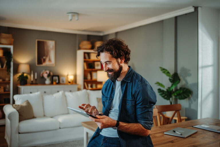 Man using a tablet in a modern living room, representing the comfortable lifestyle and residential appeal of Heaton BD9.