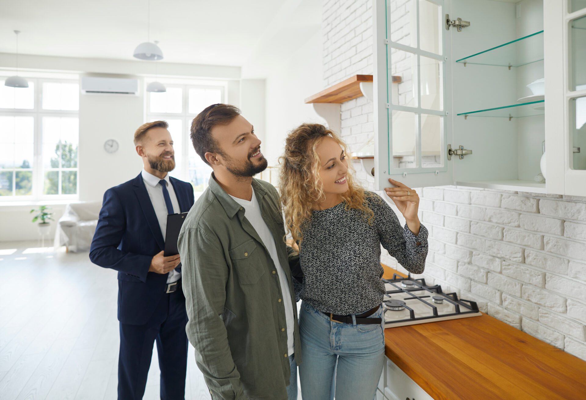 Estate agent showing a modern kitchen to a couple during a property viewing, representing buying and living in Lockerbie DG11.