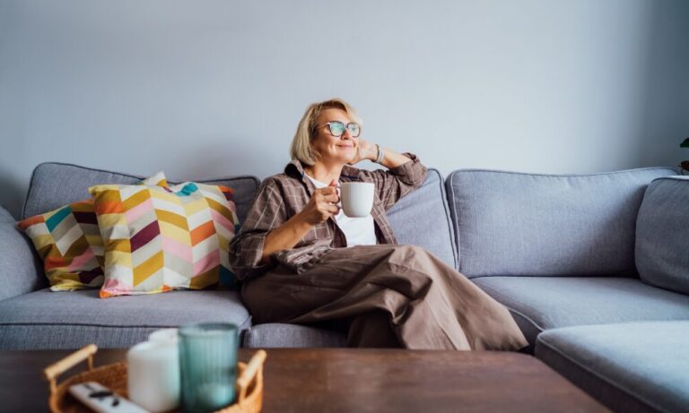 Woman relaxing on a sofa in a modern living room, representing comfortable village living in Polesworth B78.