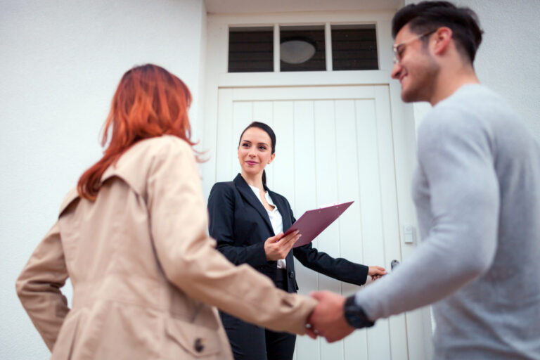 Landlord meeting with a letting agent outside a rental property