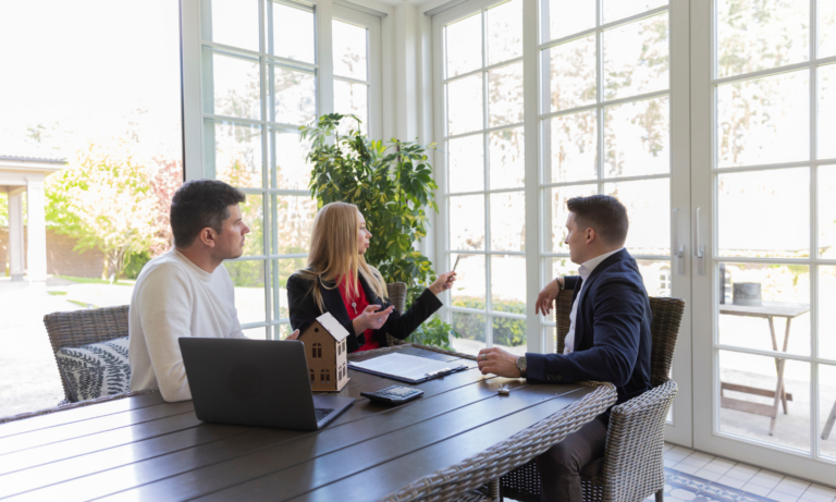Homeowners discussing their property with an estate agent while preparing to sell in Lichfield.