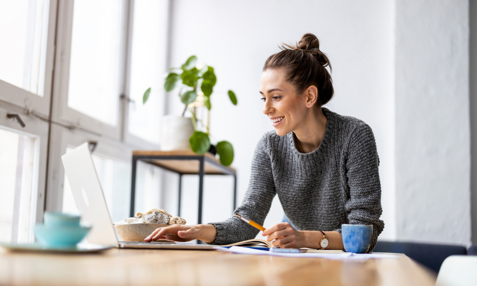 Woman using a laptop at home while researching house prices and property in Knowle.