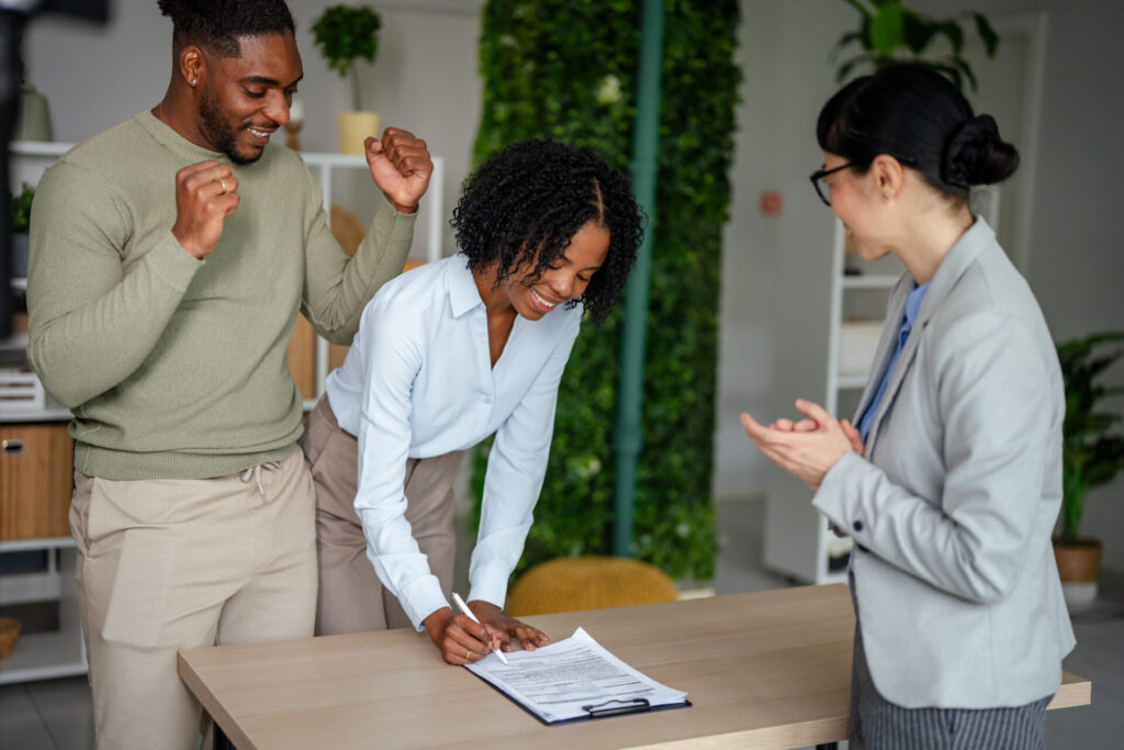 Buyer signing property documents with an estate agent in Bradford.