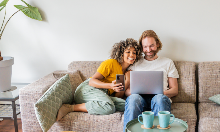Couple using a laptop at home while researching their property options online.
