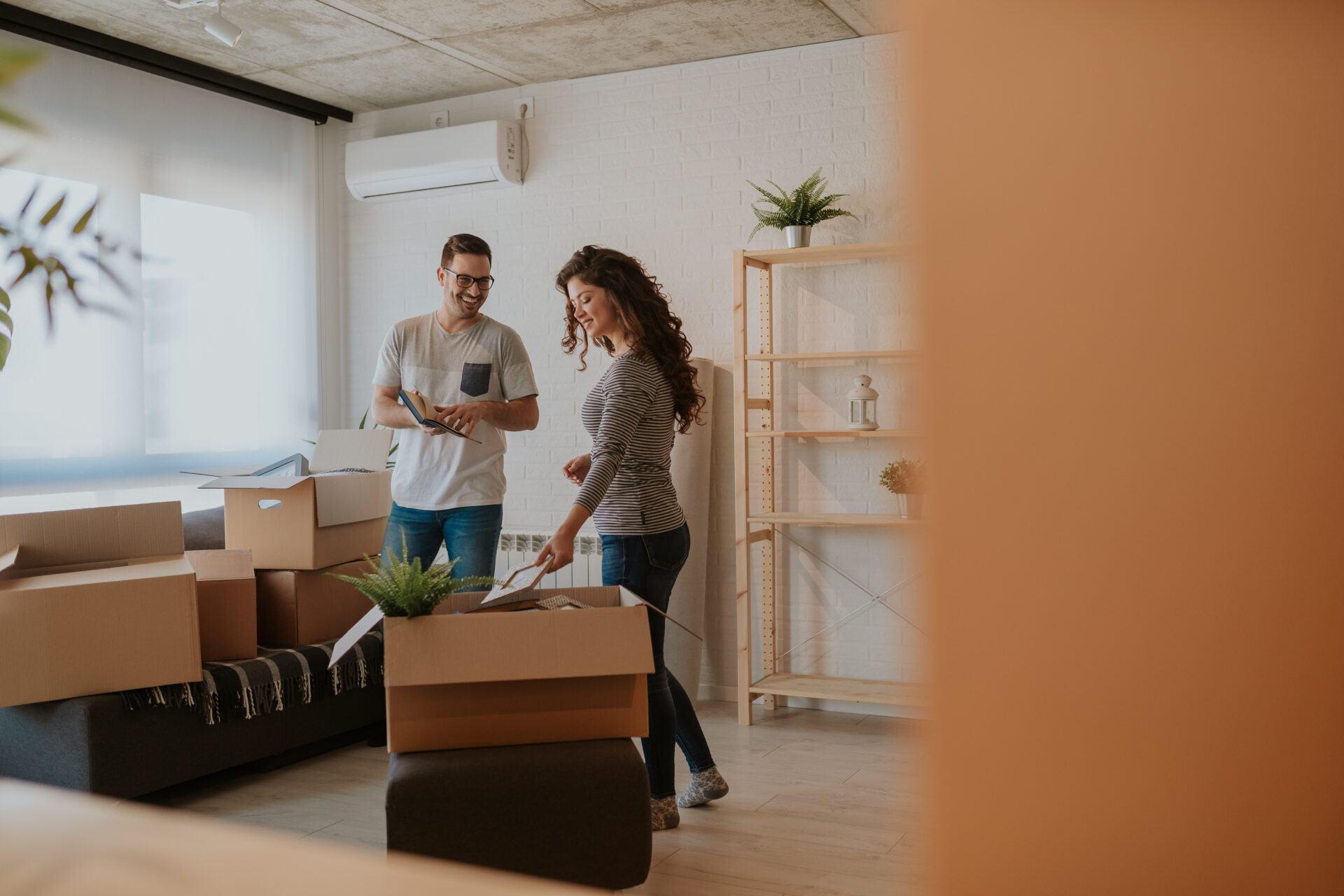Couple unpacking boxes in a modern apartment, representing moving into a rental home in Ancoats M4.