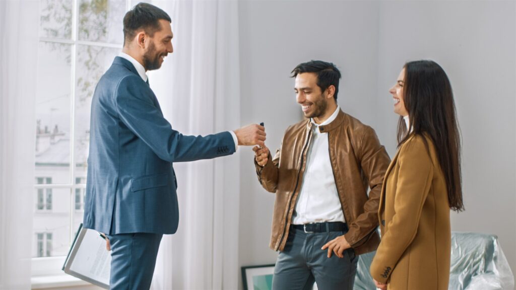 Estate agent handing house keys to new homeowners