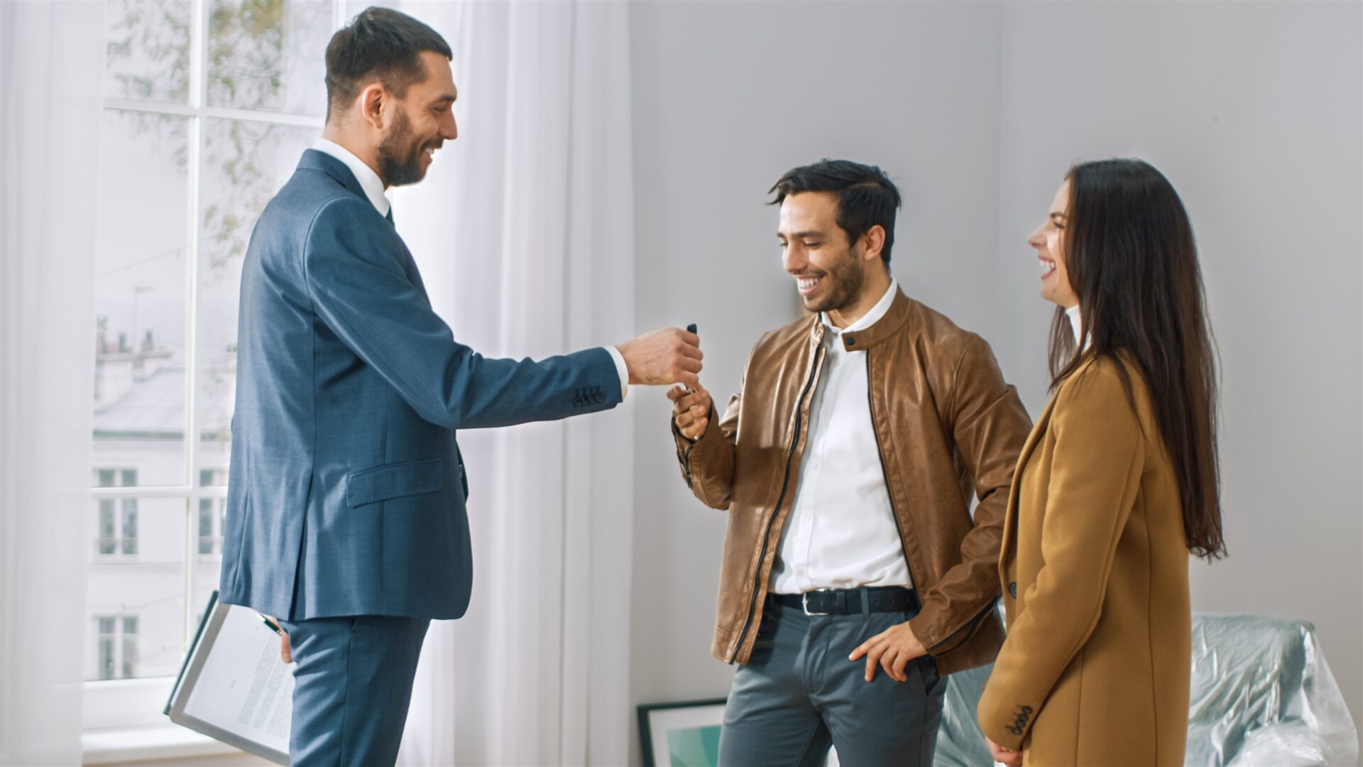 Estate agent handing house keys to new homeowners