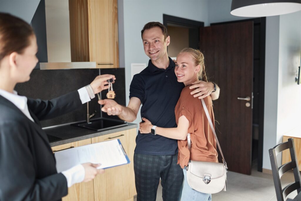 Estate agent handing keys to a happy couple