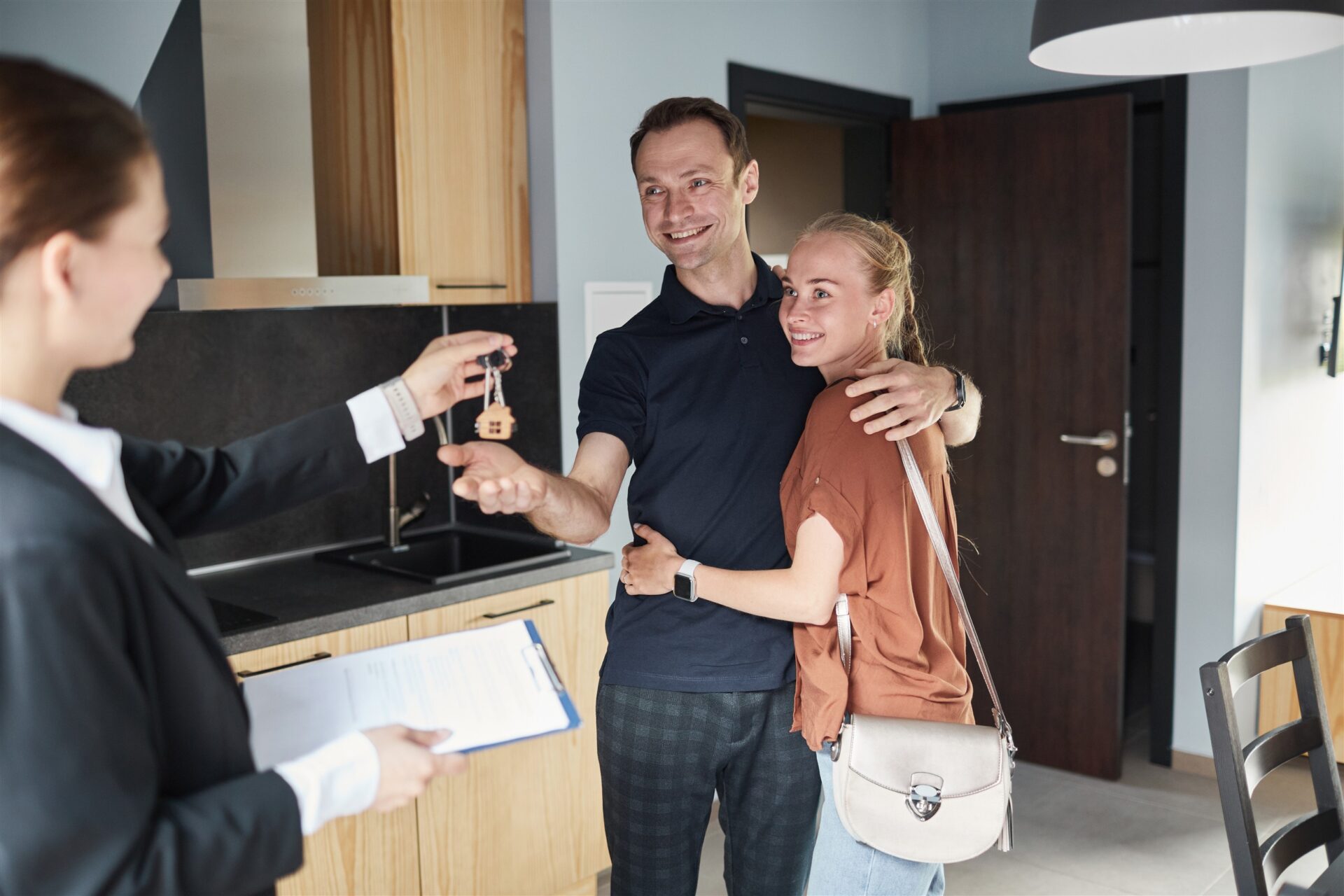Estate agent handing keys to a happy couple