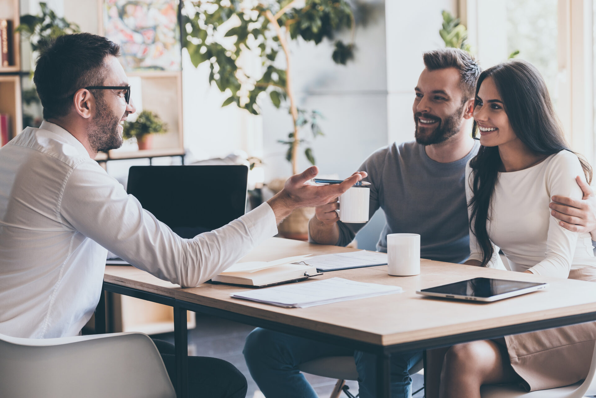 Property adviser discussing a rental with a couple at a table
