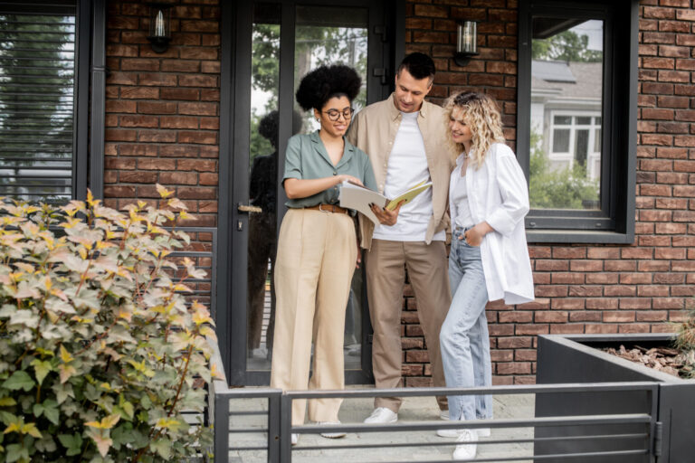 Letting agent discussing property paperwork with landlords outside a modern Southampton home.