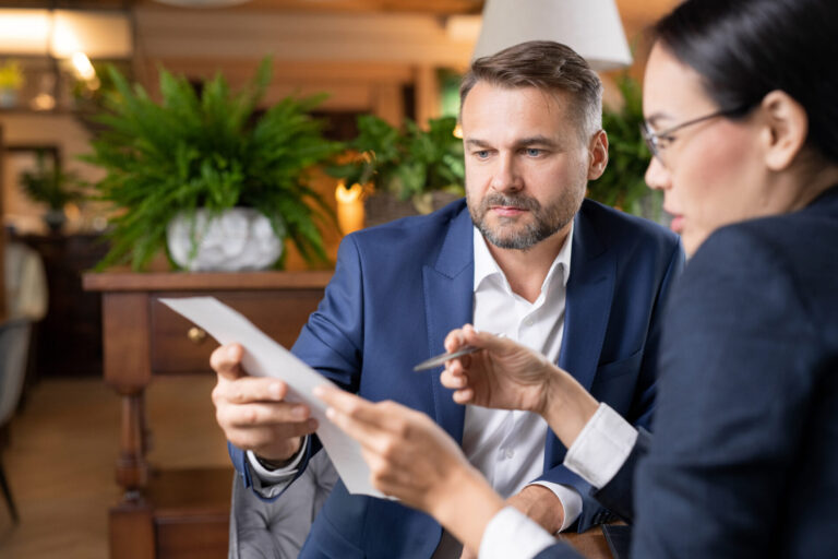 Letting agent explaining property documents and legal requirements to a landlord.