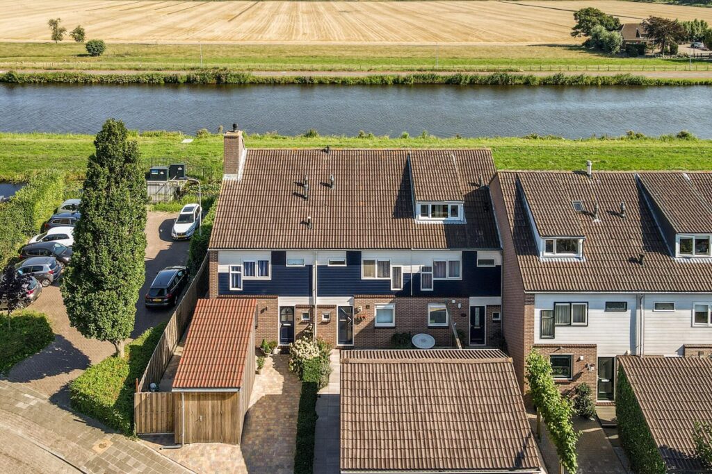 Aerial view of residential houses beside a river and countryside, representing buy-to-let property and the UK rental market.