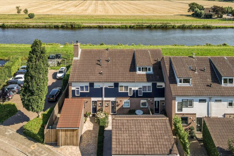 Aerial view of residential houses beside a river and countryside, representing buy-to-let property and the UK rental market.