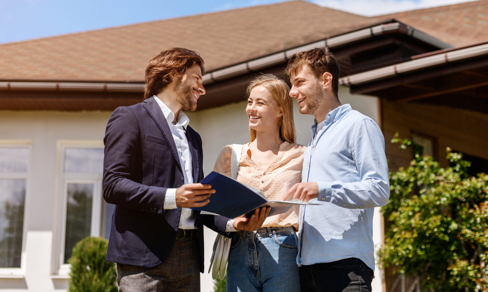 Estate agent talking with a couple outside a family house on a sunny day, reflecting the strong demand for Harrogate’s semi-detached homes.