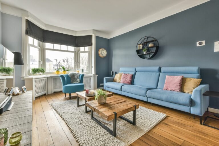 Well-presented rental living room with a blue sofa and bay window in a Gravesend home