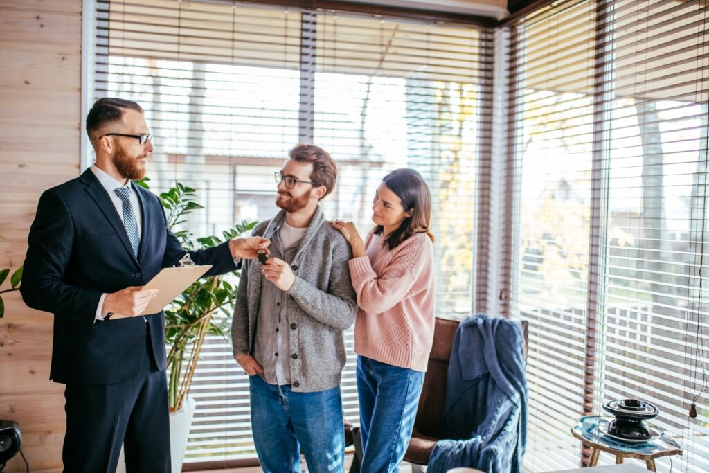 Letting agent handing keys to a young couple in a modern rented apartment in Manchester