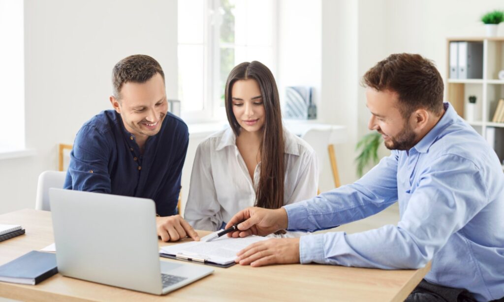 Couple reviewing rental yield figures for a Manchester buy-to-let with a Hunters adviser at a laptop
