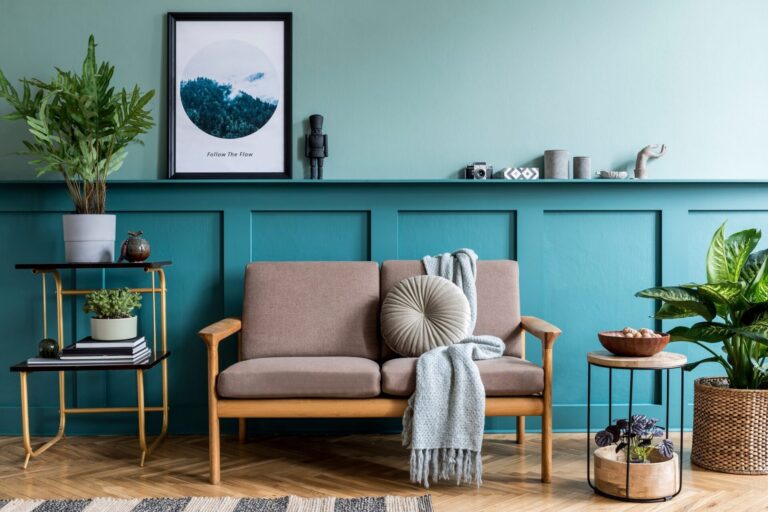 Stylish living room with teal wall panelling, sofa and plants in a well-presented Harrogate rental