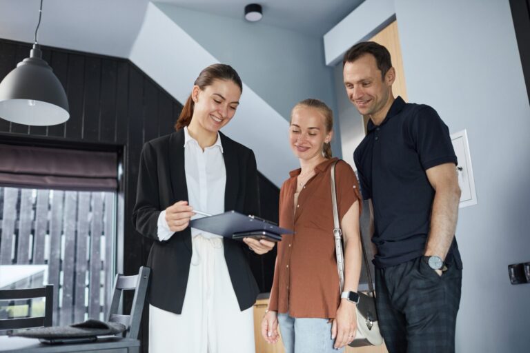 Letting agent with a clipboard showing a couple around a modern rental home, illustrating re-letting rules for Leeds landlords